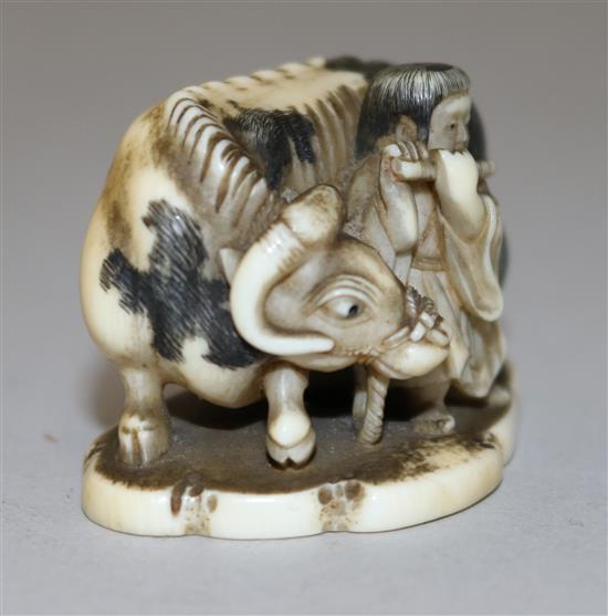 A Japanese ivory netsuke of a figure playing the flute standing by an ox, 19th century, 4.4cm